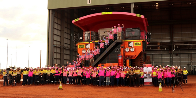 로이힐 광산 직원들이 5,500만톤 규모 최단시간 구축(Fastest ramp up to 55Mtpa in Australia)이라는 축하 배너와 함께 기념 사진을 찍는 모습