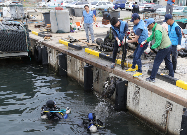 포스코 클린오션봉사단 수중봉사자가 지난 8일 포항 발산리 항구에서 폐타이어를 수거하여 지상봉사자에게 전달하고 있다.