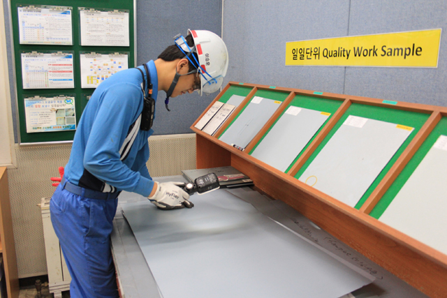 포스코 포항제철소 냉연부 직원이 도금된 철강제품의 품질을 면밀히 검사하는 모습.