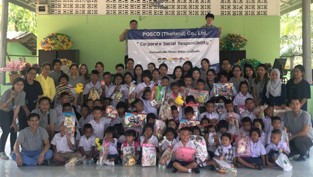 POSCO-SouthAsia 임직원들이 인근지역 반농송 초등학교에 스틸차광막과 양호실을 설치하고, 어린이들에게 선물을 나눠준 후 기념촬영을 하고 있다.