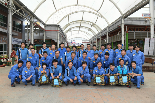 광양 5일장을 방문한 포스코 광양제철소 에너지부 직원들이 전통시장 장보기에 앞서 단체사진을 촬영하고 있다.