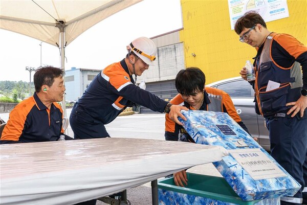 포스코 포항제철소 직원들이 그늘막 아래에서 물을 꺼내고 있다.