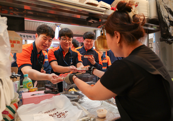 포항제철소 직원들이 대해불빛시장에서 음식을 사고 있다.